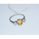 A yellow and sapphire three stone ring, the emerald-cut sapphire flanked by a pair of round