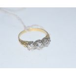 A three-stone diamond ring, early 20th century, the graduated round brilliant-cut stones claw-set on