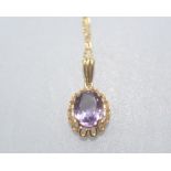 A 9ct gold amethyst pendant, the oval stone claw-set on a pierced mount, on a tracelink chain.