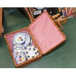 A wicker picnic hamper and contents