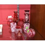 A collection of cranberry coloured glass including a pair of mottled glass tumblers, a ruby fash