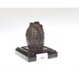 A WWI hand grenade inkwell on stand, inscribed Memento of the Great War/actual hand genade casting