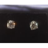 A pair of diamond stud earrings, four claw set, mounted on 18ct white gold. 1.02ct