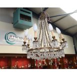 A gilt metal lustre drop eight light chandelier