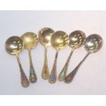 A set of six Russian silver gilt and enamel salt spoons, with beaded decorated handles, marked