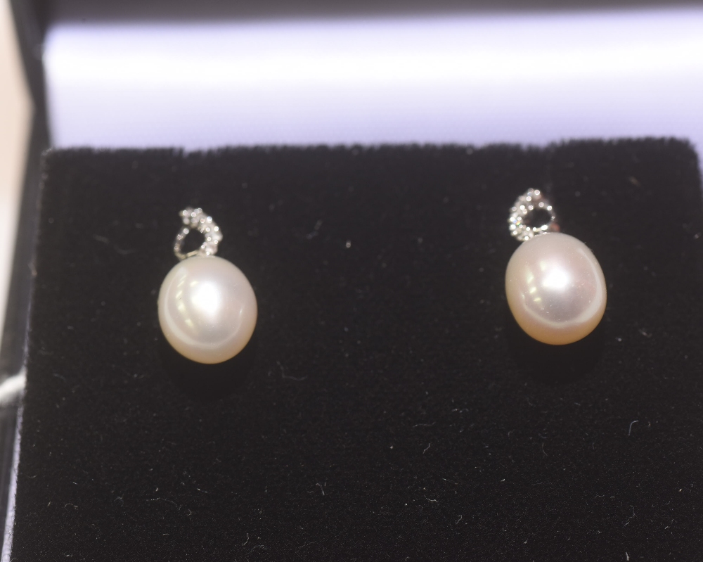 A pair of diamond and fresh water pearl drop earrings mounted in 9ct gold