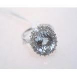 An aquamarine and diamond cluster ring on an 18ct white gold band. Aquamarine 4.82. Ring size M