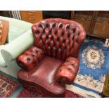 A red leather button backed armchair