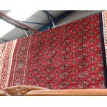 A Bokhara style carpet with red ground. 2.30 x 1.60