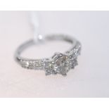 A five stone diamond ring with diamond set shoulders on an 18ct white gold band. Diamond centre 0.