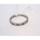 A 9ct gold eternity ring set with green and clear stones