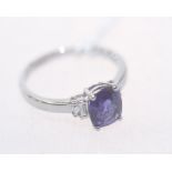 A lilac coloured sapphire ring with baguette cut diamond set shoulders on an 18ct white gold band.