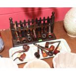 A wooden pipe rack together with an assortment of pipes (16)