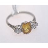 A yellow and sapphire three stone ring, the emerald-cut sapphire flanked by a pair of round