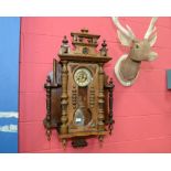 An ornate 19th century mahogany wall clock with a plethera of turned decoration