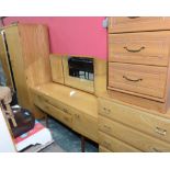 A 1950s three piece bedroom suite comprising mirror fronted wardrobe; dressing table and chest of