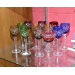 A harlequin set of eleven hock glasses in blue, cranberry, ochre and green and another glass similar