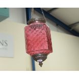 A Moroccan style cranberry glass and patinated metal hanging light