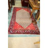 A Kurdish rug with a red ground c.1950s; tog. with a modern mat