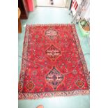 A Kurdish rug with a red ground