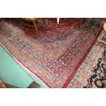 An Indo Persian small carpet with a red ground