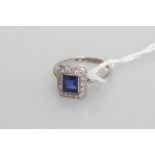 A sapphire and diamond cluster ring in the Art Deco taste, the collet-set sapphire within a band