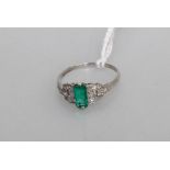 An emerald and diamond ring in the belle epoch taste, the central emerald cut emerald 0.63cts, on