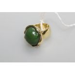 A jade cabochon and diamond ring, the oval cabochon mounted in yellow (unmarked) gold and set with a