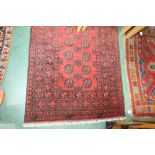 A hand made Afghan rug with a red ground, 1.92m by 1m