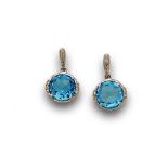 Pendientes largos con topacios azules colgantes y brillantes en montura de oro blanco de 18K.