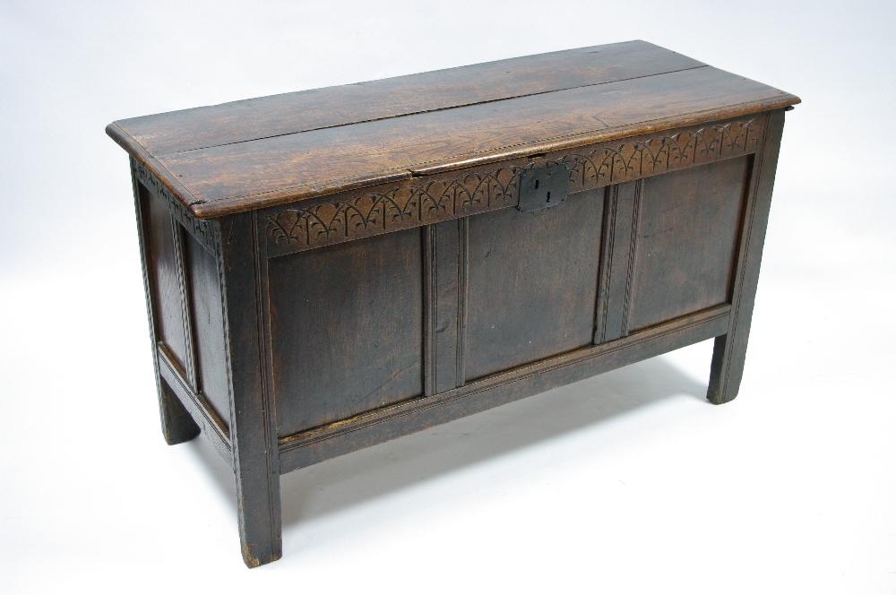 A late 17th century oak coffer with lift lid, triple-panel front, & carved frieze; 55¼" wide.