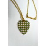 A 15ct. gold heart-shaped pendant, pave set with split-pearls & small emeralds, on yellow metal