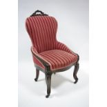 A Victorian carved rosewood frame easy chair with pierced scroll crest to the padded back, having