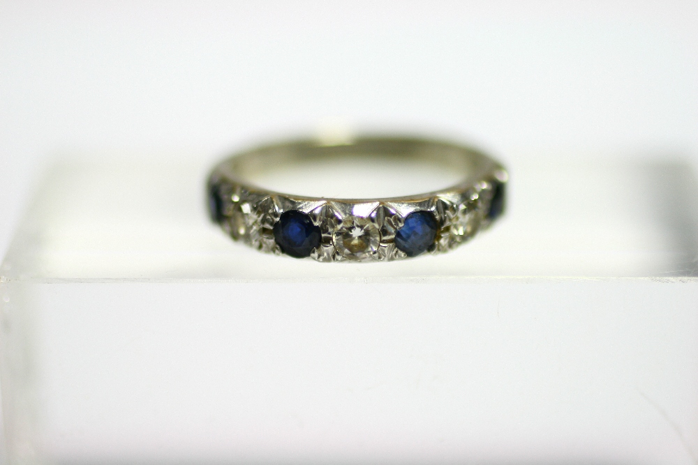 An 18ct. white gold ring set row of alternating diamonds & sapphires.