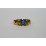 A sapphire & diamond ring, the oval sapphire bordered by three small diamonds in a crescent either