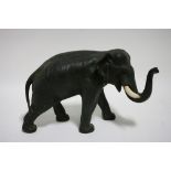 A Japanese bronze model of an Asian elephant in walking pose, its’ trunk slightly raised. 12" long x