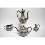 A late Victorian four-piece tea & coffee service of round semi-fluted design with scroll borders.