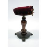 An early Victorian rosewood music seat, the circular padded rise-&-fall top on baluster column &