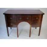 A regency mahogany small bow-front sideboard with crossbanded top, fitted centre frieze drawer above