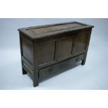 A 17th century oak coffer with lift-lid, panelled front & sides, the centre panel now forming a