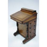A Victorian walnut davenport with hinged stationery compartment to the top, four graduated drawers