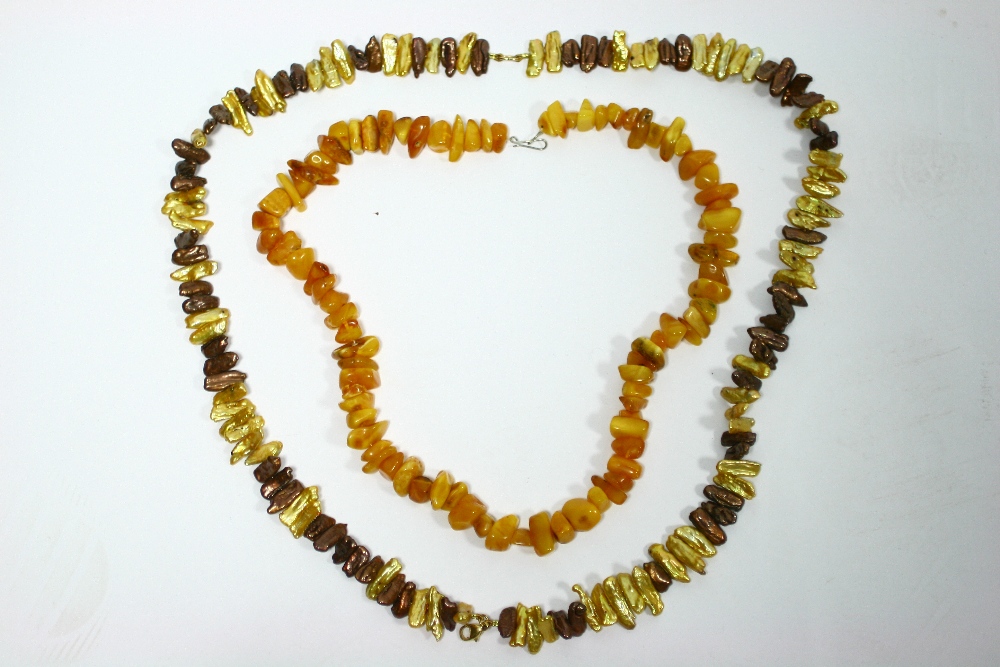 An opaque amber-chip necklace; & a “Jersey” cultured pearl necklace.