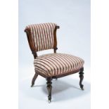 A Victorian carved rosewood frame nursing chair with low padded back & wide padded seat, on