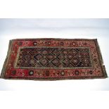 An antique Persian corridor runner, the central dark blue ground panel with trellis design, within