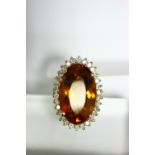 A CITRINE & DIAMOND RING, the large oval stone of deep orange-amber colour measuring approx. 22 x