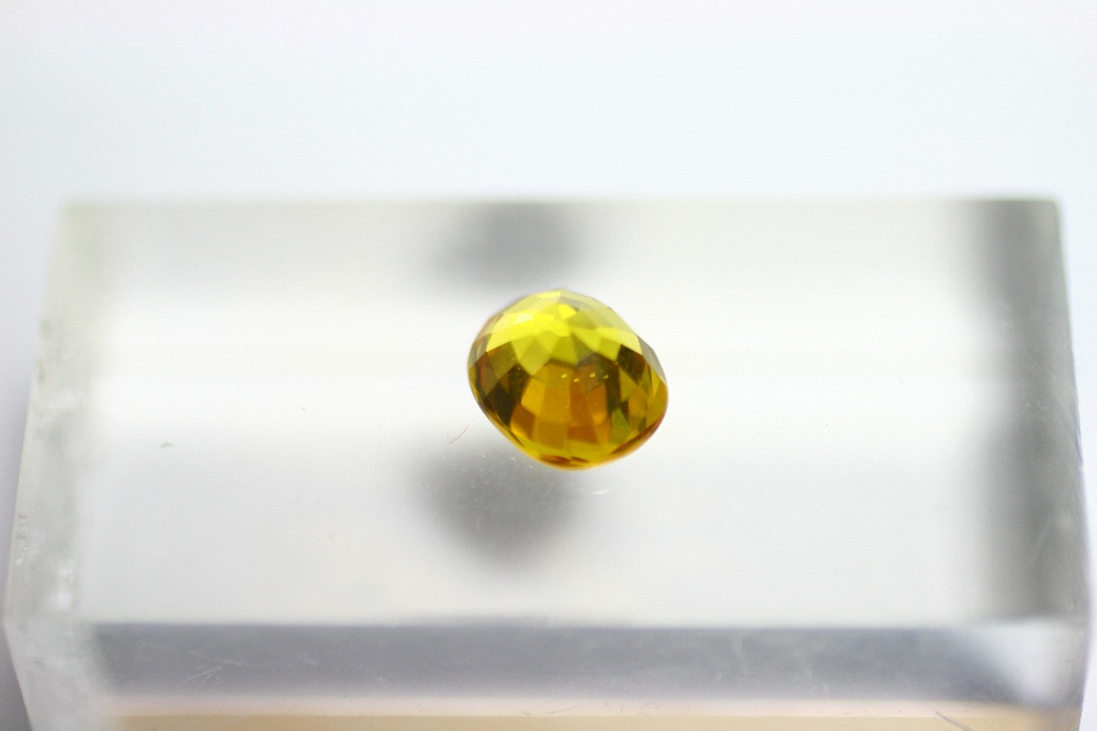 An un-mounted yellow sapphire, oval cut, measuring approx. 10mm x 8mm x 6mm deep.