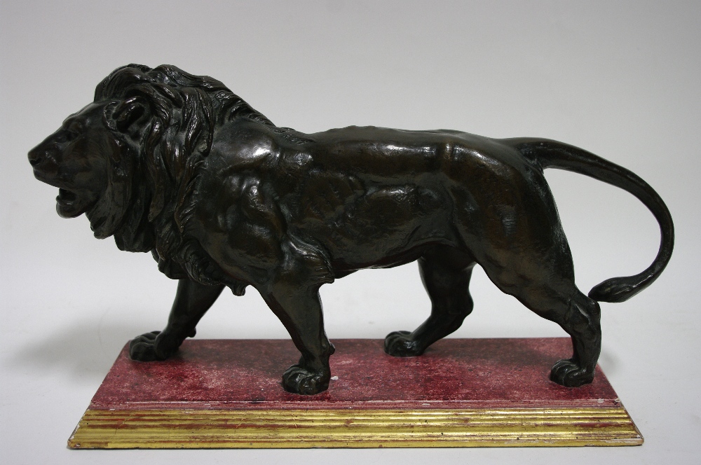 A bronze model of a walking male lion after A. L. Barye; 16" long x 8" high, on wooden base.