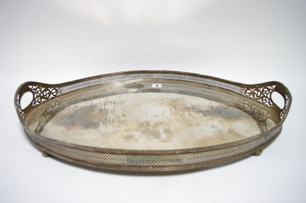 A large oval two-handled tea tray with gadrooned rim to the pierced gallery, on four bun feet; 26" x