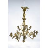 A 19th century pressed gilt-metal chandelier with fifteen leaf-scroll arms with foliate sconces