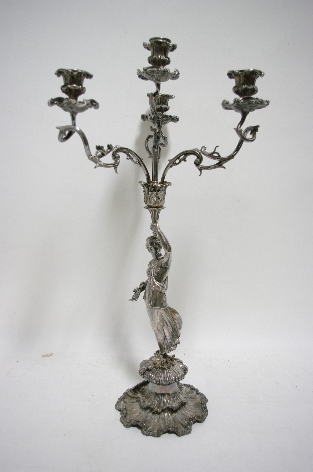 A Victorian table candelabrum having three foliate scroll arms & matching central upright sconce